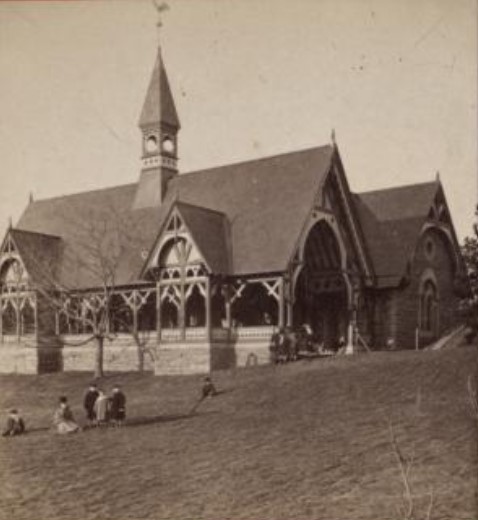 An angled front view of the Dairy, with several people sitting on the lawn in front.